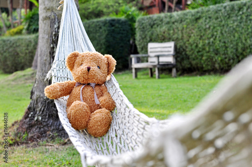 Teddy bear lying in the beach cradle. Concept about loneliness.