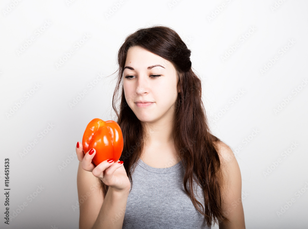 beautiful young woman eating an red pepper. healthy food - strong teeth concept beautiful young woman eating an red pepper. healthy food - strong teeth concept