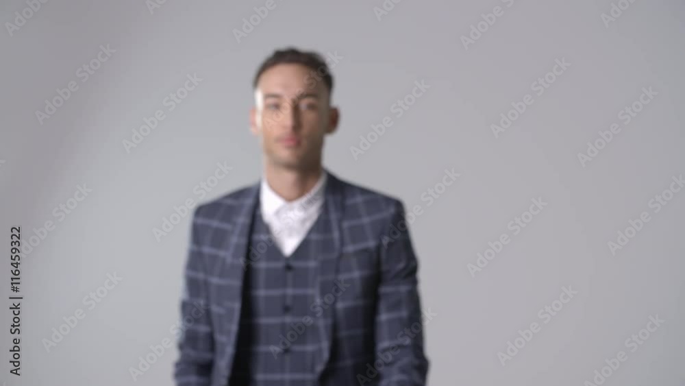 Smiling man in suit walks to camera, into focus, and turns Smiling man in suit walks to camera, into focus, and turns