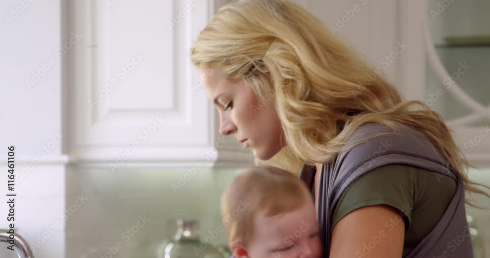 Busy Mother With Baby In Sling At Home Busy Mother With Baby In Sling At Home