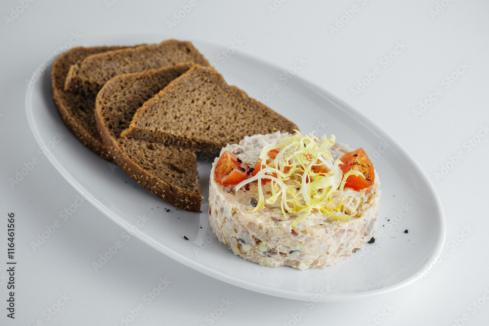 russian salad with tomato and black bread on a white plate russian salad with tomato and black bread on a white plate
