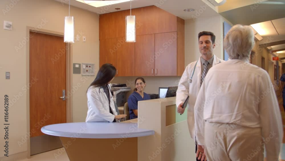 Medical Staff At Busy Nurses Station In Hospital Medical Staff At Busy Nurses Station In Hospital