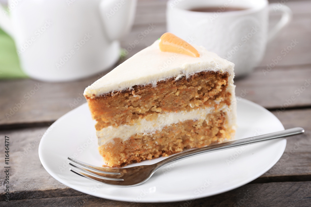 Delicious carrot cake with fork on wooden table