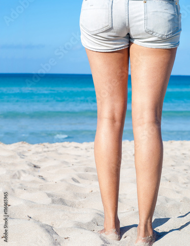 woman standing on sand beach. closeup detail of legs
