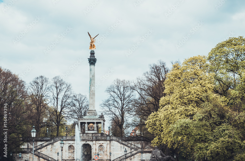 Obraz premium Golden statue atop pillar in park