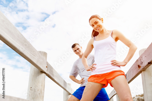 Runners. Young couple exercising and stertching on beach © Sergey Nivens