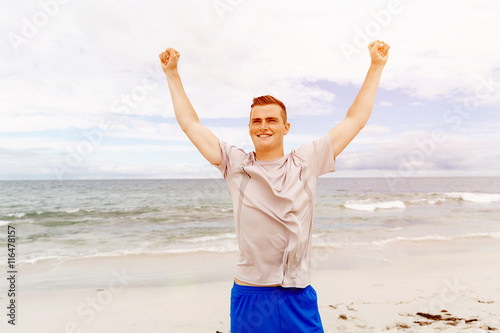 Young man in sport wear with outstretched arms