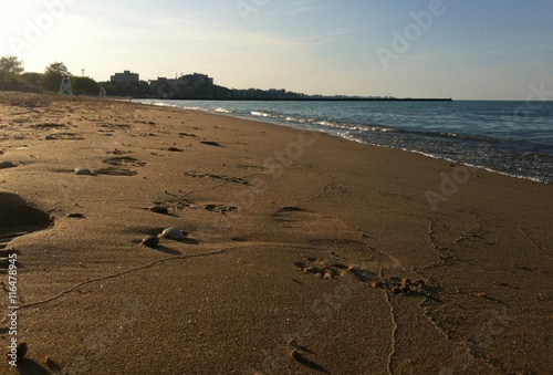 Sandy beach with foot prints at the lake shore during summer