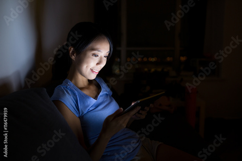 Woman using tablet at night