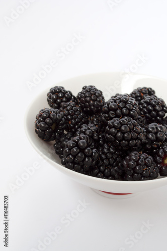 Blackberries in a white plate on a white background