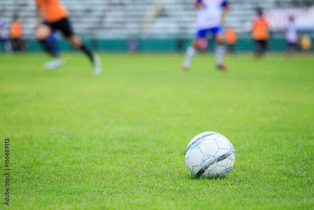 Soccer ball on the field and blur of player in stadium Soccer ball on the field and blur of player in stadium