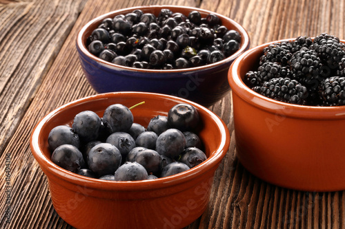 Fresh blueberries and blackberries on old wooden background