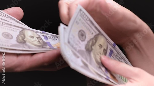 Female hands give US dollar banknotes for man or business partner. Woman accountant with money bills.