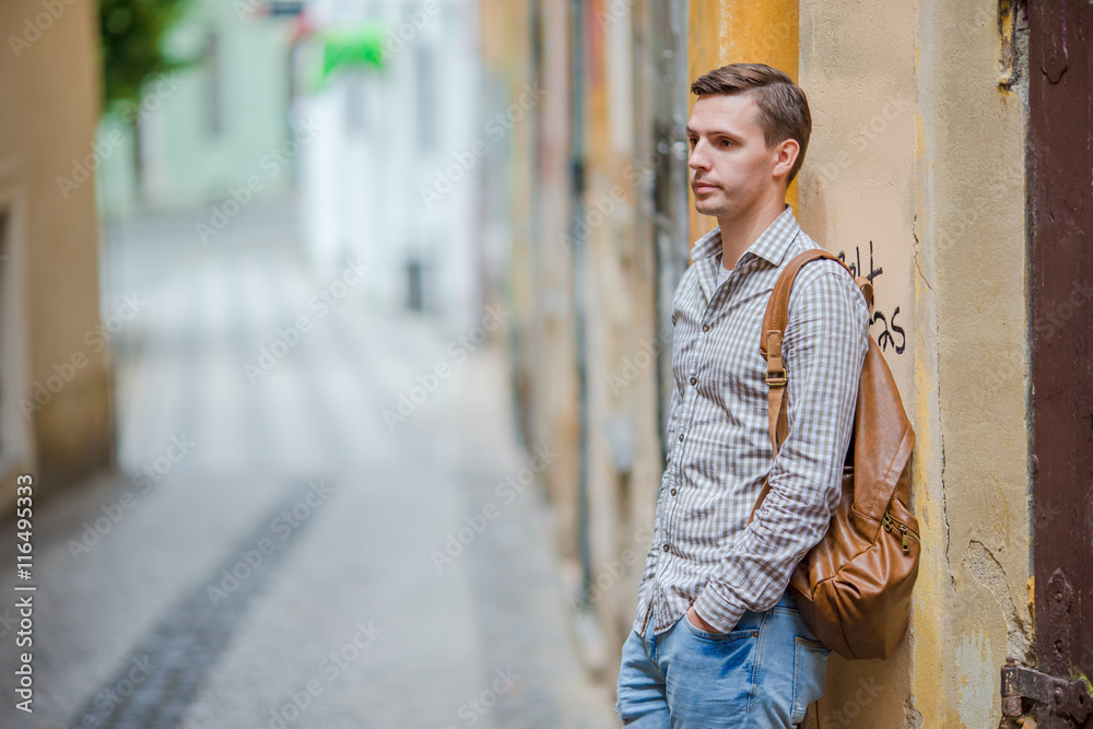 Caucasian tourist walking along the deserted streets of Europe. Young urban boy on vacation exploring european city