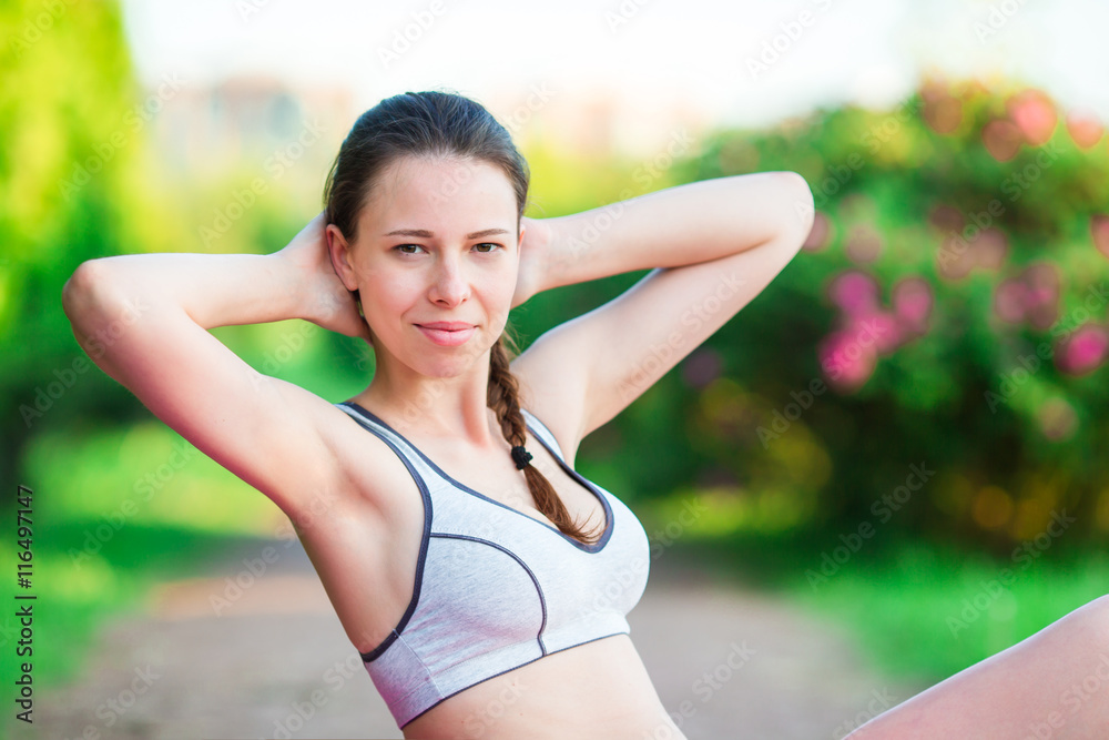 Fitness runner body doing warm-up routine in the park before running, stretching leg muscles with standing single knee to chest stretch. Female athlete preparing legs for cardio workout. Fitness runner body doing warm-up routine in the park before running, stretching leg muscles with standing single knee to chest stretch. Female athlete preparing legs for cardio workout.