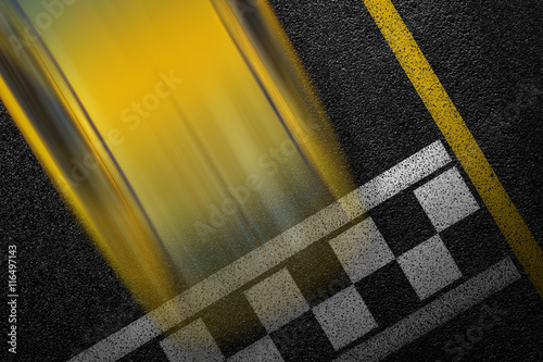 Level asphalted road with a dividing stripes and moving with high speed a yellow sport car. The texture of the tarmac, top view.