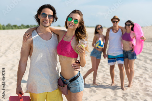 Cheerful smiling friends resting on the beach