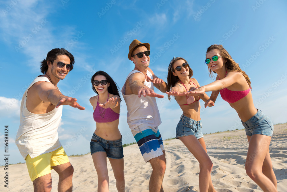 Cheerful smiling friends having fun on the beach Cheerful smiling friends having fun on the beach
