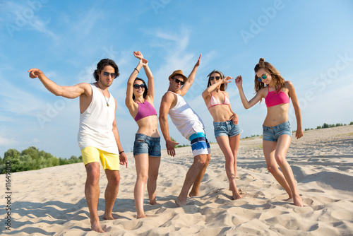 Delighted overjoyed friends standing on the beach