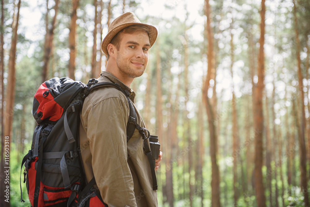 Joyful young man traveling in forest