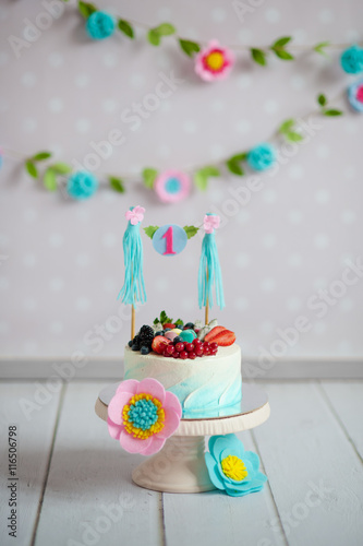 Birthday cake decorated with fruits and a garland