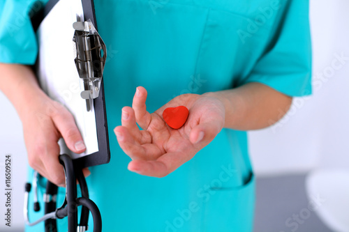 Female surgeon doctor with stethoscope holding heart. © rogerphoto