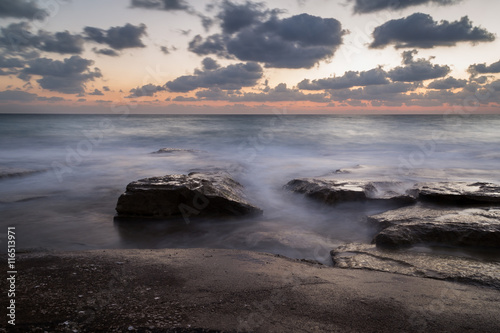 Long exposure creating dreamy water effect on the rocks after sunset, Nahariya Beach