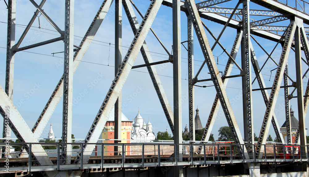 Railway metal bridge perspective view. Russian monastery on backdrop Railway metal bridge perspective view. Russian monastery on backdrop