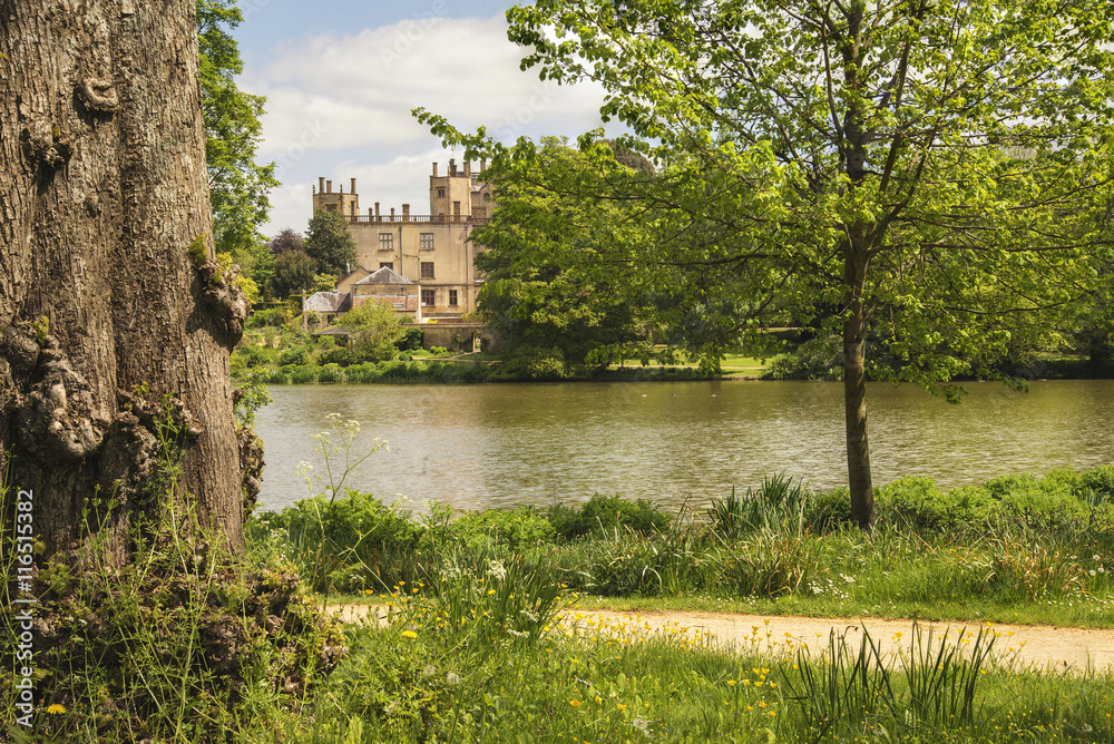 Fototapeta premium Landscape image of old Victorian house viewed across lake on Sum