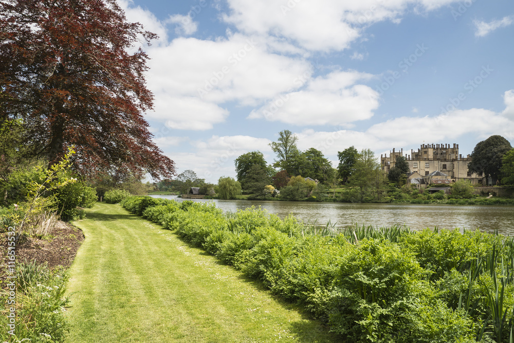 Obraz premium Landscape image of old Victorian house viewed across lake on Sum