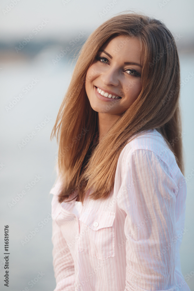 Portrait of a beautiful woman,brunette with long straight hair and gray eyes,a nice smile ,dressed in a white shirt resting on the shore of the blue ocean in the summer in the fresh air Portrait of a beautiful woman,brunette with long straight hair and gray eyes,a nice smile ,dressed in a white shirt resting on the shore of the blue ocean in the summer in the fresh air