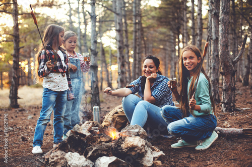 Children by the fire in autumn forest