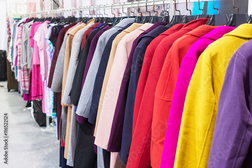 Multi-colored coat hanging on hangers.