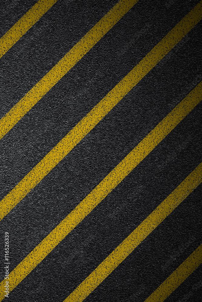 Fototapeta premium Level asphalted road with a dividing yellow stripes. The texture of the tarmac, top view.