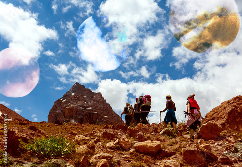 Surrealistic Alien Planet Mountain View and Group of People Hikers walking up on red Mountain Trail © alexbrylovhk