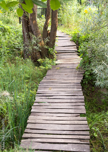 Wooden planks path over the ditch vertical © yurich84
