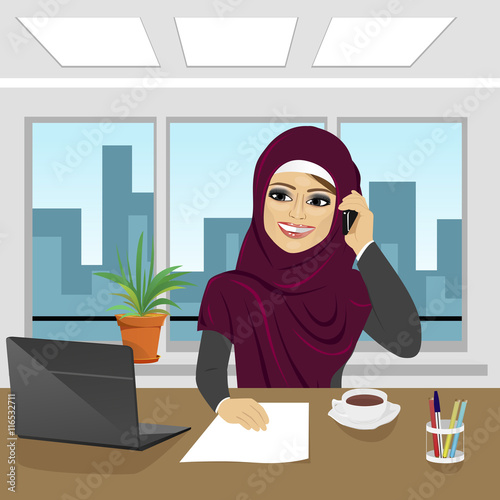 business arab woman with laptop at office wearing hijab talking on phone