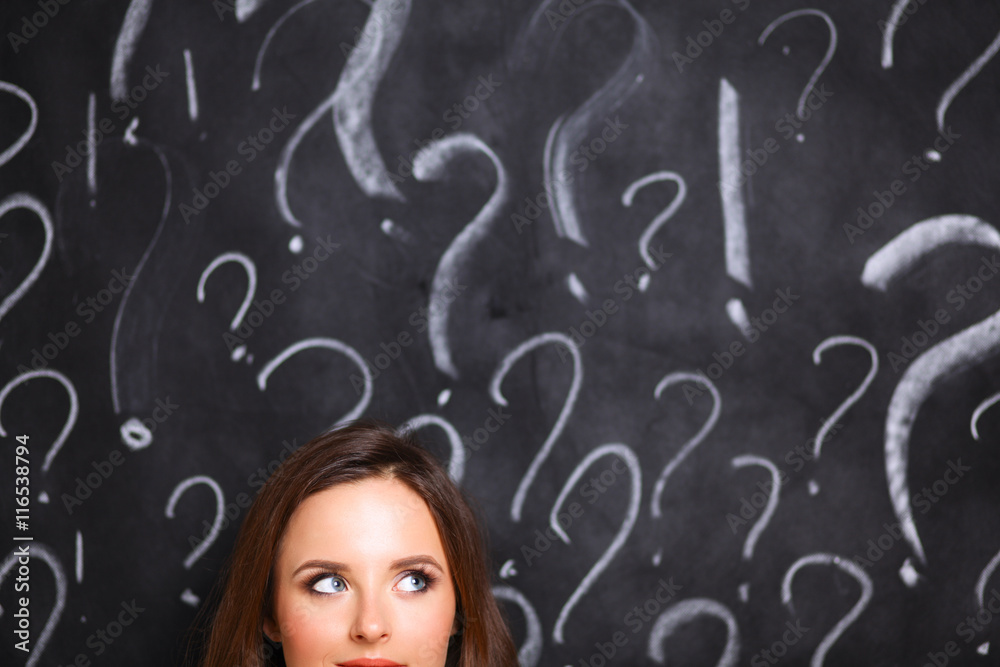 Young girl with question mark on a gray background Young girl with question mark on a gray background