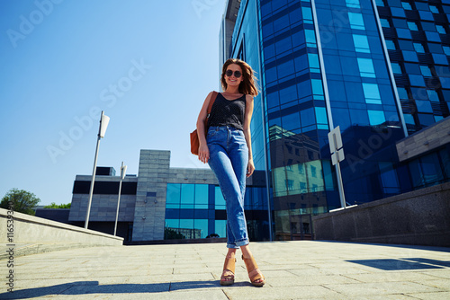 Slim attractive young woman on business center background