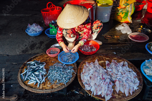 фотографія Woman sells fish at the morning market, Vietnam