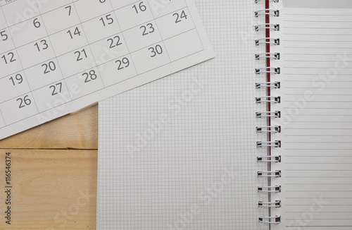 calender and paper natebook on wood table photo