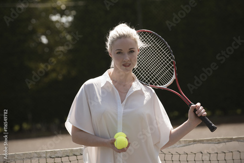 PORTRAIT OF A YOUNG TENNIS PLAYER -JULY 2016 - A young female tennis player with fair hair holding a raquet and tennis balls © petert2