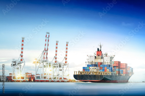 Logistics and transportation of International Container Cargo ship with ports crane bridge in harbor for logistic import export background and transport industry.