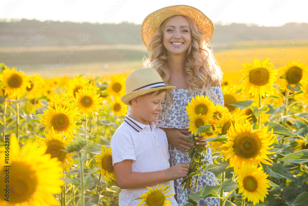 Beautiful woman with son in sunflower field Beautiful woman with son in sunflower field