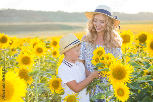 Beautiful woman with son in sunflower field © Kirill Grekov