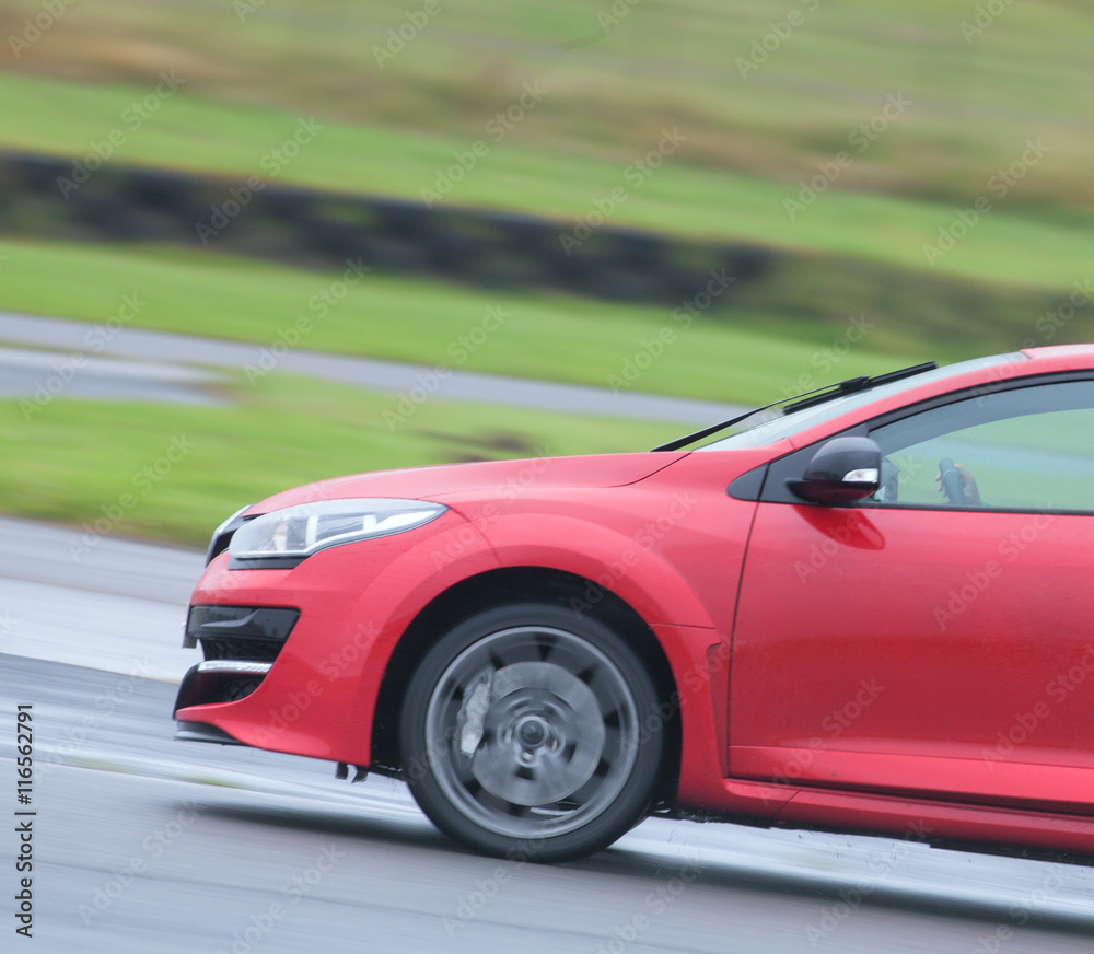 Red road car zooming around a race track