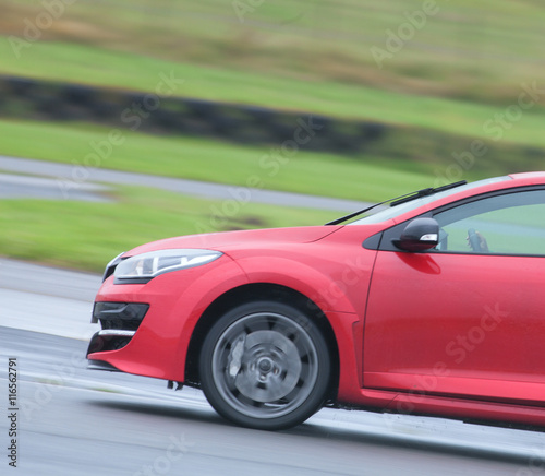Red road car zooming around a race track