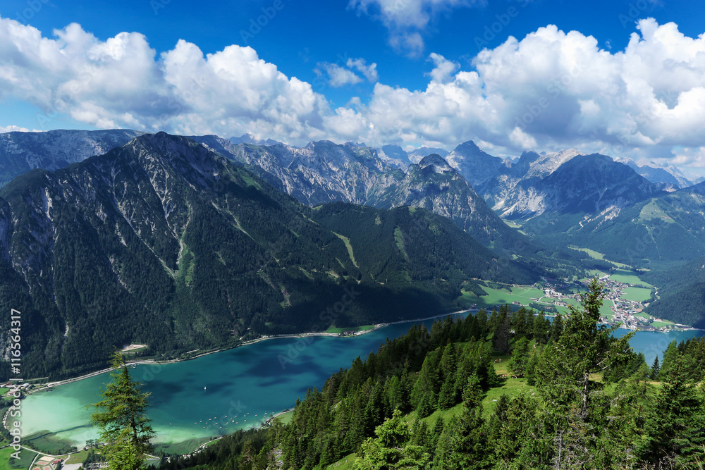 Aerial view of blue mountain lake between forested rocky mountains. Achensee, Austria, Tyrol