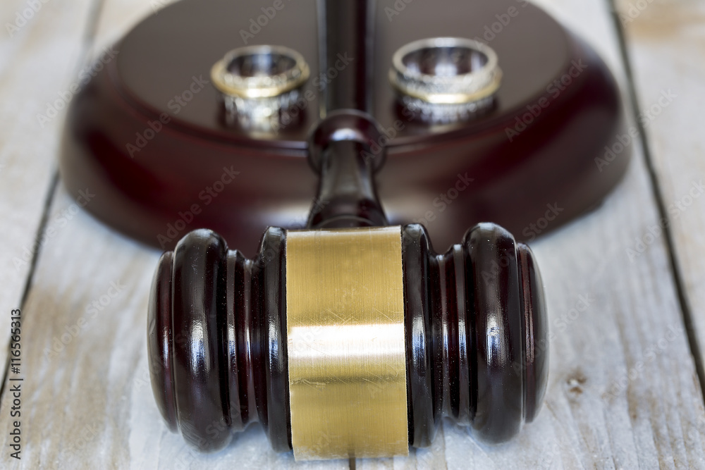 Divorce concept. Close up of wedding rings and judge gavel Divorce concept. Close up of wedding rings and judge gavel