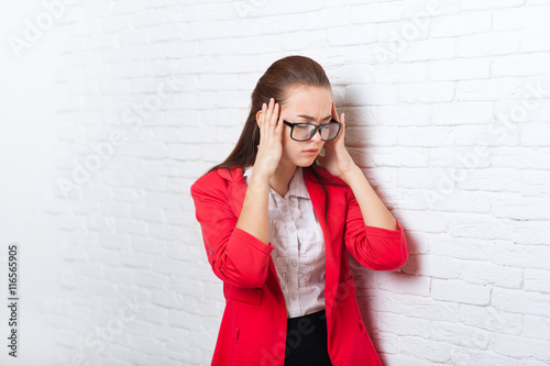 Businesswoman hold hands on head, ache, pain depressed wear red jacket glasses stressed